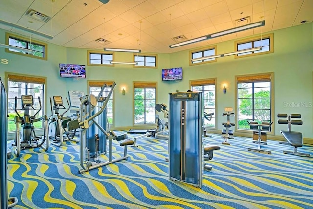 gym with a towering ceiling and carpet floors