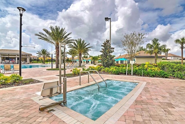 view of swimming pool with a community hot tub and a patio