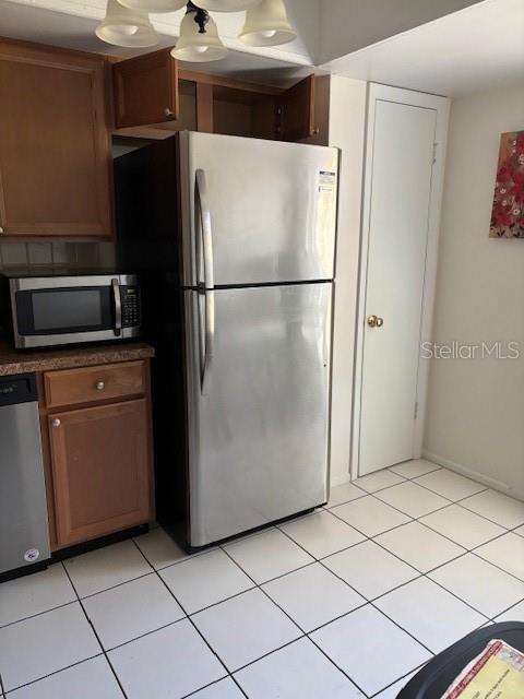 kitchen with stainless steel appliances and light tile patterned flooring