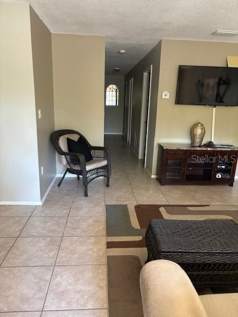 hallway featuring light tile patterned floors and a textured ceiling