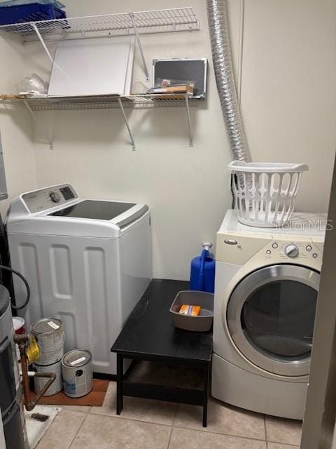 washroom featuring light tile patterned floors and washing machine and dryer