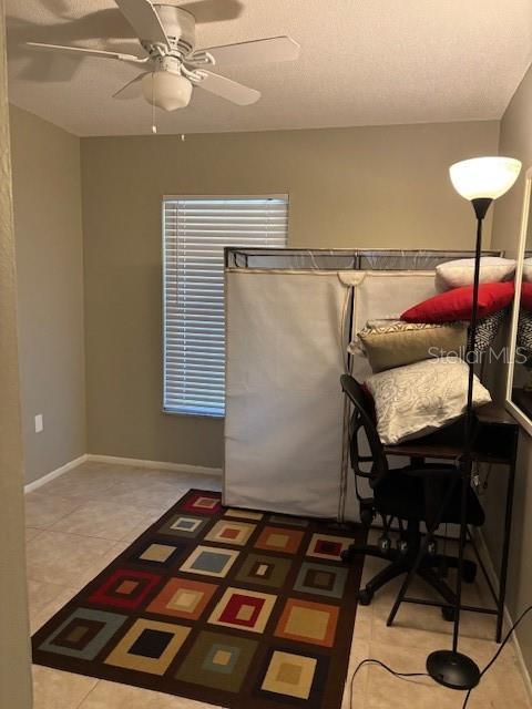 tiled dining room featuring ceiling fan and a textured ceiling