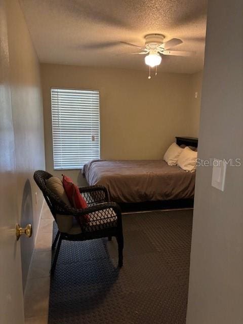 bedroom with a textured ceiling and ceiling fan