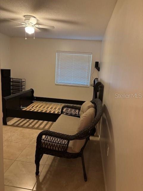 living area featuring ceiling fan and light tile patterned floors