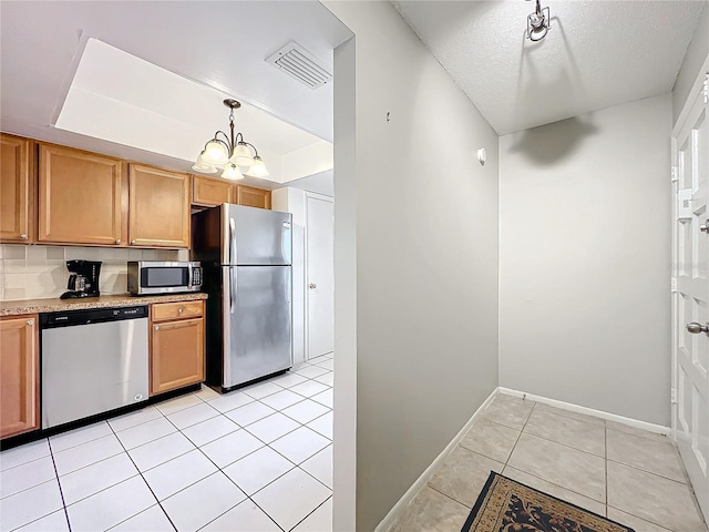 kitchen featuring light tile patterned flooring, a notable chandelier, visible vents, appliances with stainless steel finishes, and a raised ceiling