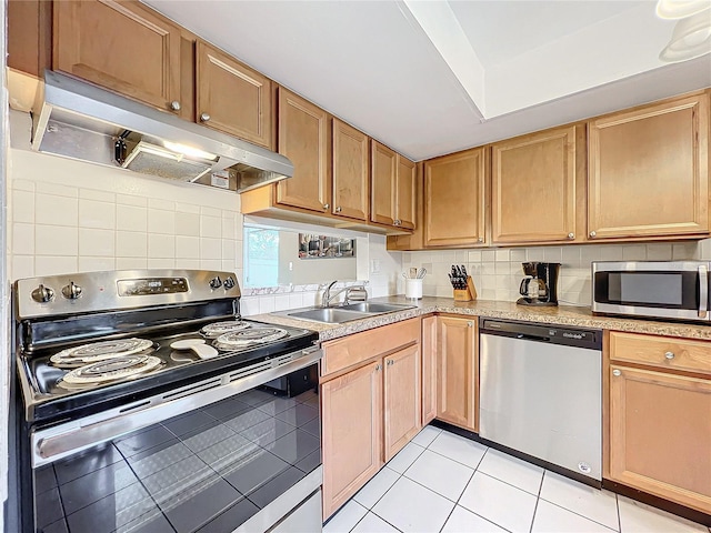 kitchen featuring stainless steel appliances, light countertops, light tile patterned flooring, a sink, and under cabinet range hood