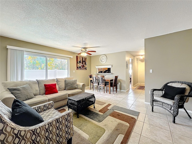 living room with baseboards, a textured ceiling, and light tile patterned flooring