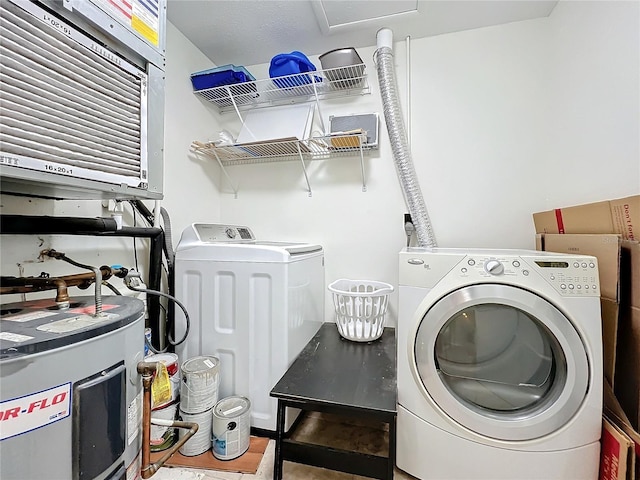 clothes washing area featuring water heater, laundry area, and washing machine and clothes dryer