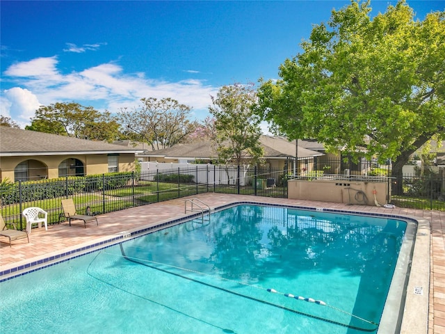 community pool with fence and a patio