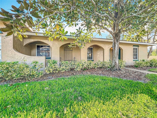 view of front of home with a front yard and stucco siding