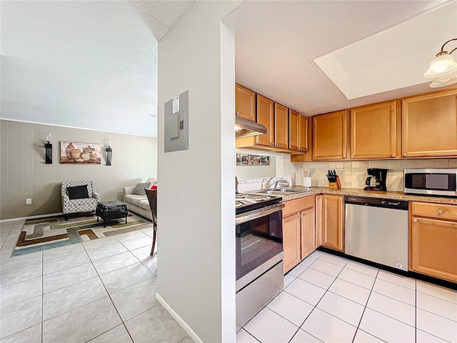 kitchen featuring light countertops, appliances with stainless steel finishes, light tile patterned flooring, a sink, and electric panel