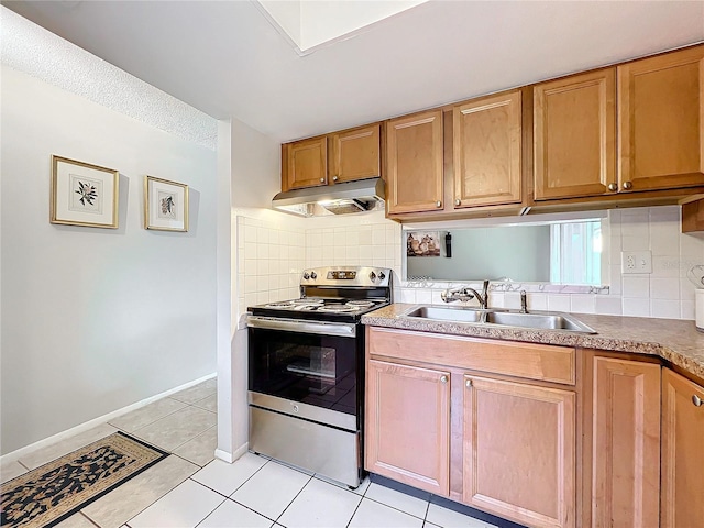 kitchen with tasteful backsplash, stainless steel electric stove, under cabinet range hood, a sink, and light tile patterned flooring