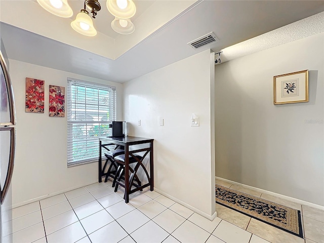 dining space featuring light tile patterned floors, a notable chandelier, visible vents, baseboards, and a raised ceiling