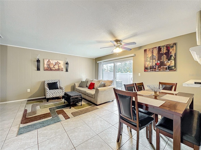 dining area with light tile patterned floors, ceiling fan, a textured ceiling, and baseboards