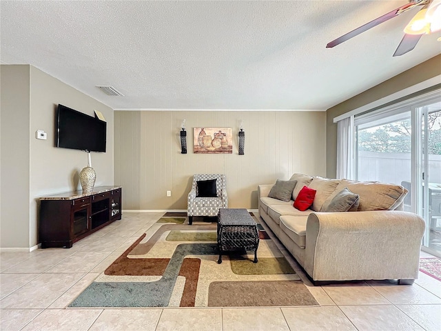 living area with light tile patterned floors, baseboards, visible vents, and a textured ceiling