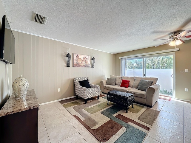 living room featuring visible vents, ceiling fan, a textured ceiling, and light tile patterned floors