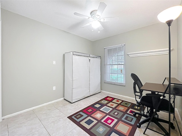 office featuring light tile patterned flooring, ceiling fan, a textured ceiling, and baseboards