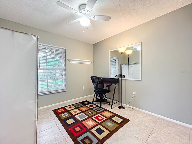 office featuring light tile patterned floors, ceiling fan, a textured ceiling, and baseboards