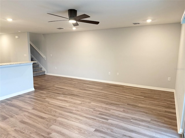 empty room with visible vents, stairway, baseboards, and wood finished floors