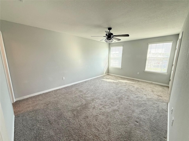 carpeted empty room featuring ceiling fan, baseboards, and a textured ceiling