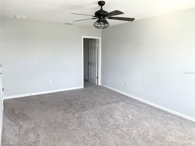 carpeted empty room featuring visible vents, ceiling fan, and baseboards