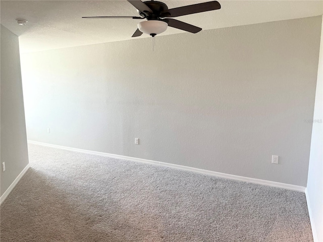 empty room featuring a textured ceiling, carpet floors, ceiling fan, and baseboards