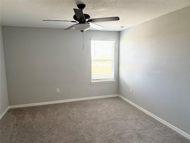 carpeted spare room with a textured ceiling, ceiling fan, and baseboards