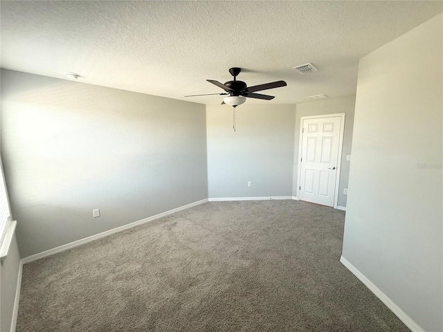 empty room with carpet floors, visible vents, ceiling fan, a textured ceiling, and baseboards