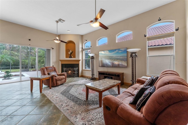 living room featuring ceiling fan and a towering ceiling