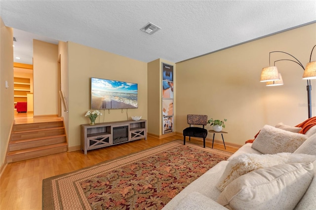 living room featuring wood-type flooring and a textured ceiling