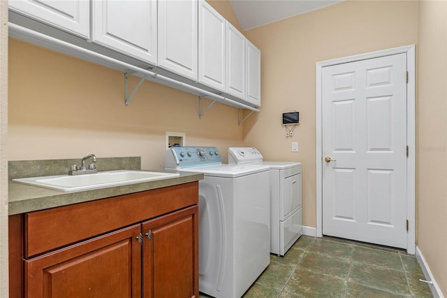 clothes washing area featuring cabinets, washing machine and dryer, and sink