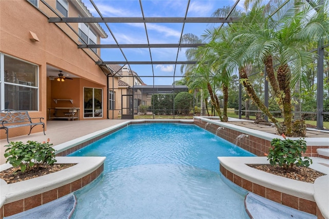 view of swimming pool with pool water feature, a lanai, a patio area, and ceiling fan