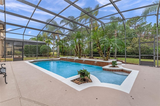 view of pool with glass enclosure, a patio area, pool water feature, and an in ground hot tub