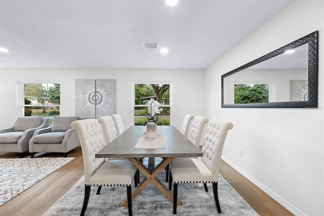 dining space with hardwood / wood-style flooring and a healthy amount of sunlight