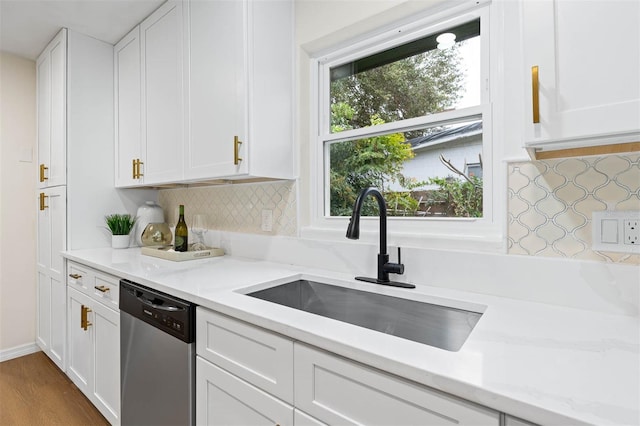 kitchen with dishwasher, white cabinetry, a healthy amount of sunlight, and sink