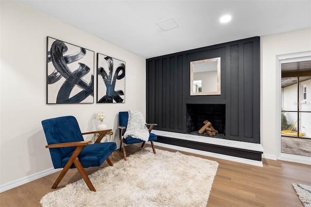 sitting room featuring a fireplace and hardwood / wood-style floors