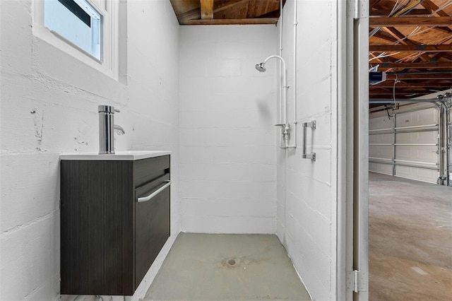 bathroom featuring a shower, vanity, and concrete floors