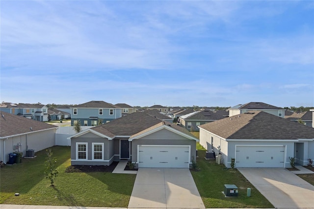 view of front of home with a front yard, a garage, and central AC unit