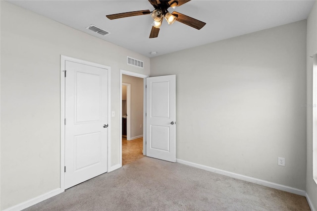 unfurnished bedroom with ceiling fan and light colored carpet