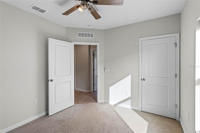 unfurnished bedroom with ceiling fan and light colored carpet