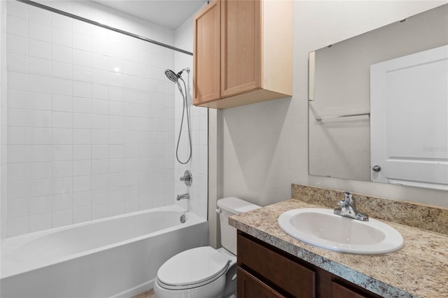 full bathroom featuring tiled shower / bath, vanity, and toilet