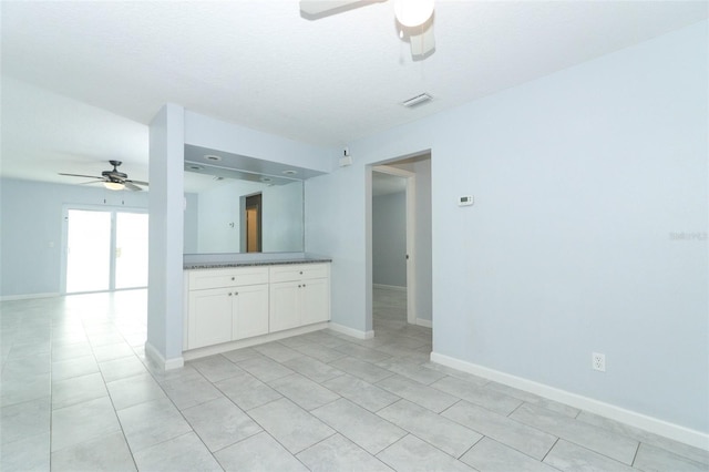 spare room with ceiling fan and light tile patterned floors