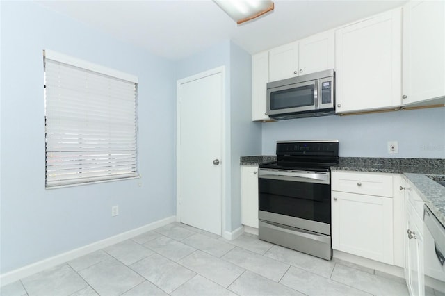 kitchen featuring appliances with stainless steel finishes, white cabinetry, and dark stone counters