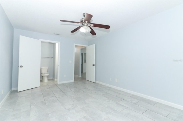 unfurnished bedroom featuring ceiling fan, light tile patterned flooring, and ensuite bath