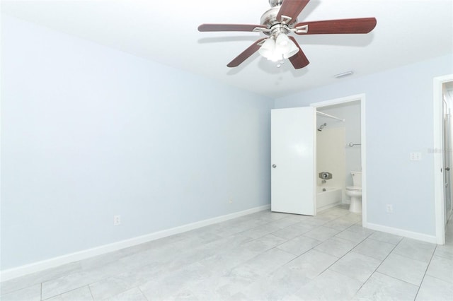 unfurnished bedroom featuring ceiling fan, light tile patterned floors, and ensuite bath