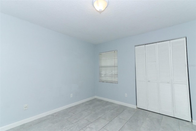 unfurnished bedroom featuring a textured ceiling and a closet