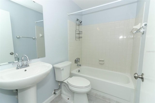 full bathroom featuring tile patterned flooring, toilet, tiled shower / bath, and sink