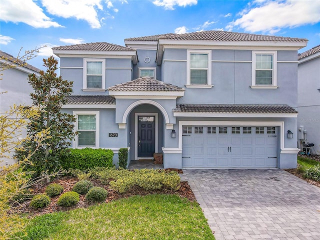 1670 Moon Valley Dr, Davenport, FL 33896 - view of front of property with a tiled roof, decorative driveway, stucco siding, and an attached garage