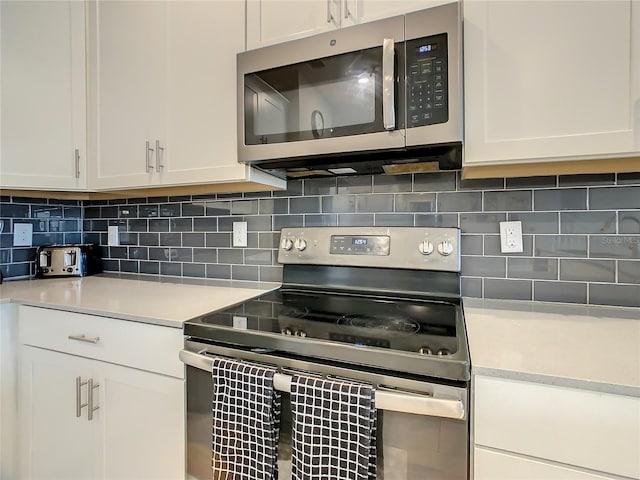 1670 Moon Valley Dr, Davenport, FL 33896 - kitchen with stainless steel appliances, light countertops, white cabinets, and backsplash