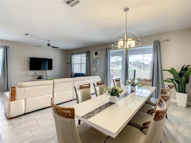 tiled dining room featuring ceiling fan with notable chandelier